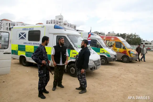 Palestinian Hamas security stand next to a car of a British aid convoy for Gaza, in Gaza City, 10 March 2009. British MP George Galloway arrived in Gaza at the head of an aid convoy to protest what he called Israel's 'ge...