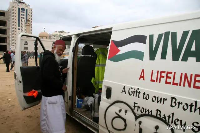 Members of a British aid convoy stand near their car in Gaza City, 10 March 2009. British MP George Galloway arrived in Gaza at the head of an aid convoy to protest what he called Israel's 'genocidal aggression' against...
