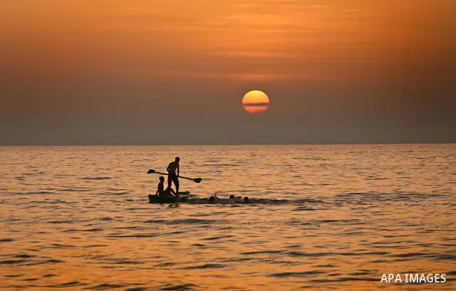 Palestinian fishermen are seen silhouetted on their boat in the Mediterranean sea during sunset to the West of Gaza city, 06 April 2012. Photo by Ali Jadallah