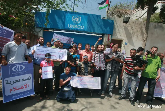 Palestinian journalists and photographers take part in a protest in support with the photographer, Mohammed Osman, in front of UNRWA headquarters in Gaza city on May 16, 2012. Photo by Naaman Omar