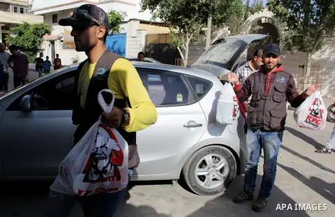 Delevery employees carry bags of food from Kentucky Fried Chicken after it arrived in Gaza City through an underground tunnel linking the Gaza Strip to Egypt, on May 16, 2013. Fast food is just the latest trend for smugg...
