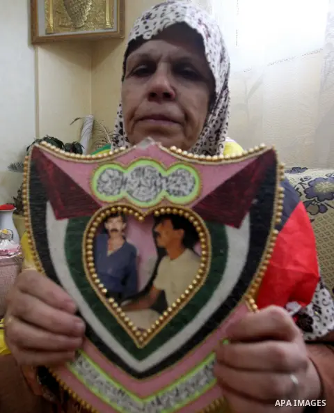 The mother of Palestinian prisoner Naje' Maqboul holds his photo at his home in the West Bank City of Hebron, Monday, Oct. 28, 2013 .Maqboul is one of 26 Palestinian prisoners that Israel approved on Sunday to release, i...
