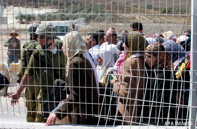Israeli soldiers stand by Palestinians crossing the Hawara checkpoint near the West Bank city of Nablus. Prime Minister Ehud Olmert on Sunday hinted there would be no major breakthroughs in peacemaking ahead of a U.S. sp...