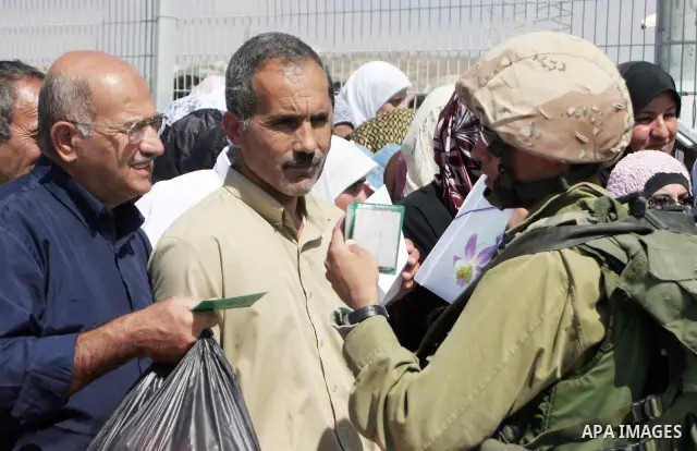 Israeli soldiers stand by Palestinians crossing the Hawara checkpoint near the West Bank city of Nablus. Prime Minister Ehud Olmert on Sunday hinted there would be no major breakthroughs in peacemaking ahead of a U.S. sp...