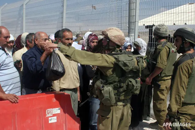 Israeli soldiers stand by Palestinians crossing the Hawara checkpoint near the West Bank city of Nablus. Prime Minister Ehud Olmert on Sunday hinted there would be no major breakthroughs in peacemaking ahead of a U.S. sp...