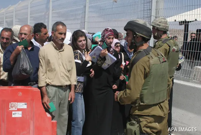 Israeli soldiers stand by Palestinians crossing the Hawara checkpoint near the West Bank city of Nablus. Prime Minister Ehud Olmert on Sunday hinted there would be no major breakthroughs in peacemaking ahead of a U.S. sp...