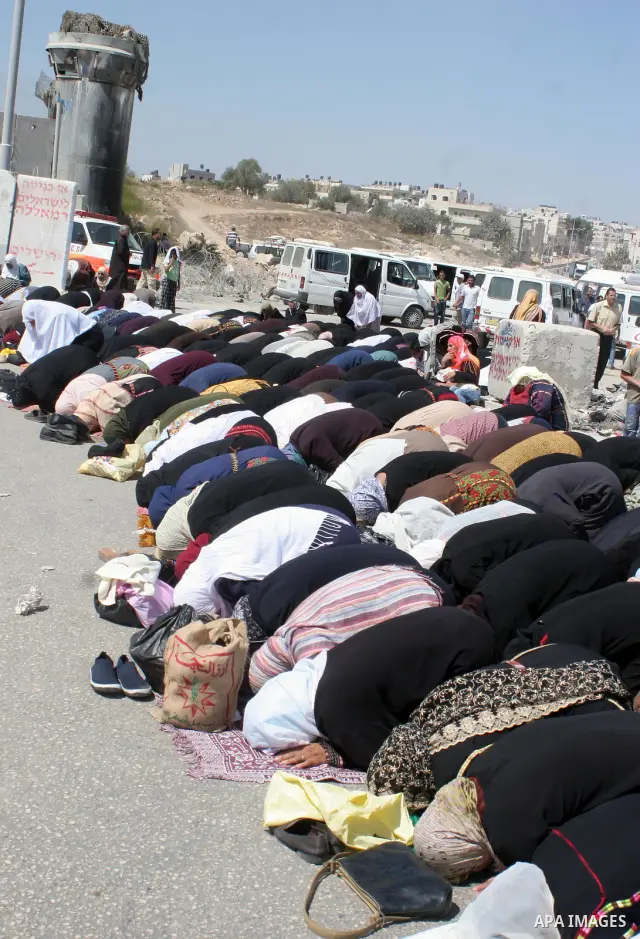 Palestinian worshippers wait hoping to cross the Israeli manned Qalandiya checkpoint and controversial separation barrier, to go to Jerusalem to take part in prayers at the al-Aqsa mosque, the third most holy site for Mu...