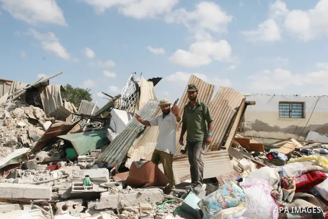 Palestinians inspect the rubble of a house, which was demolished by the Israeli army during a military operation in El-Bureig, Gaza strip