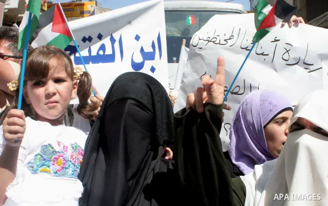 Palestinian women protesters gather with banners calling for the release of imprisoned family members linked to the Islamist Hamas movement and an end to political arrests outside Al-Bireh mosque in the West Bank city of...