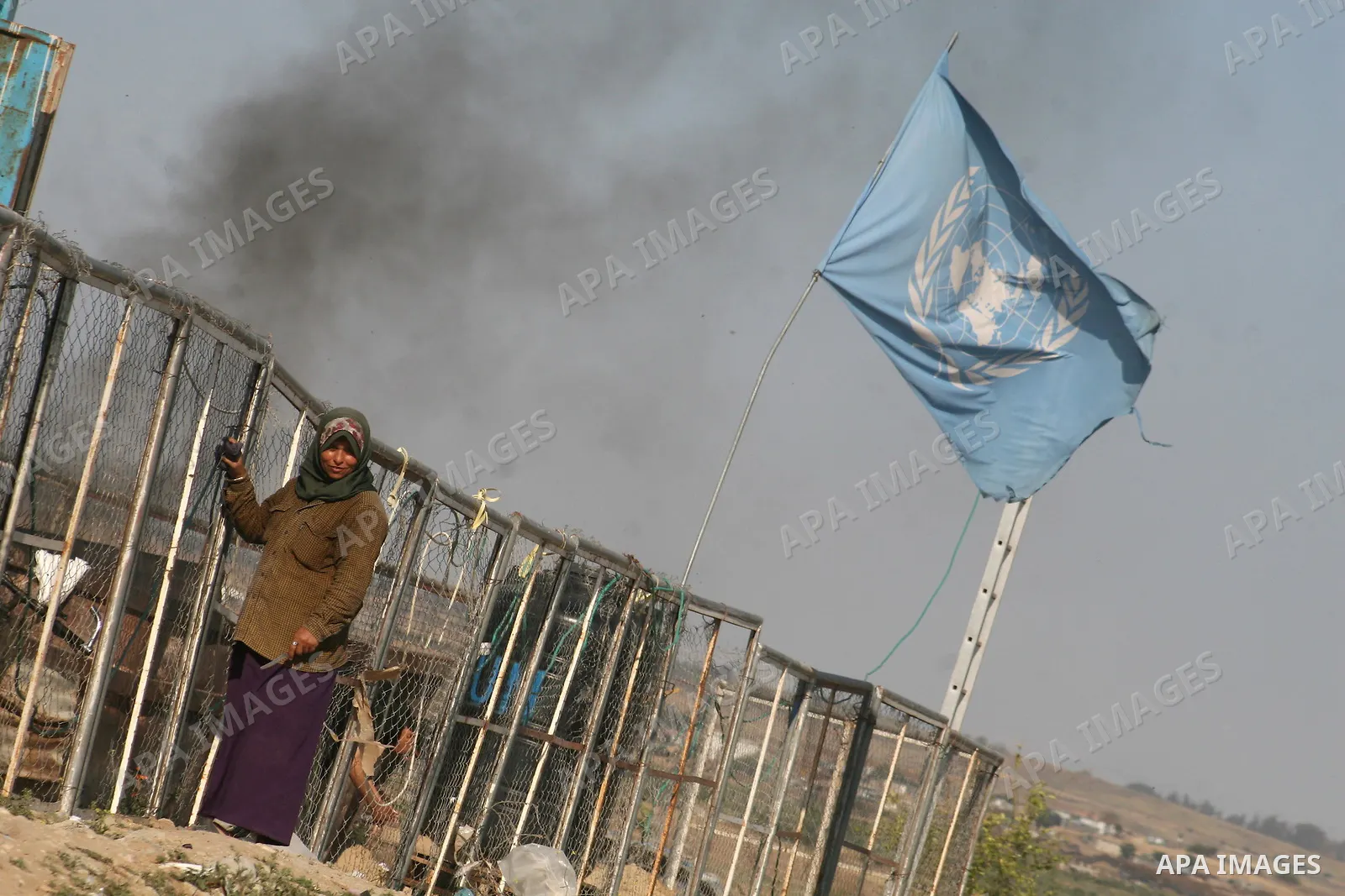 Palestinian stand outside temporary tents for the United Nations Relief and Works Agency (UNRWA) for Palestinian refugees near houses that were destroyed during Israel's 22-day offensive, in Jabalia refugee camp in the n...