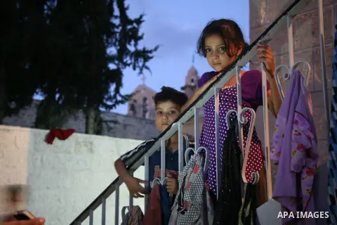 Displaced Palestinian children stand at the stairs of a Greek Orthodox church where many Palestinians are taking shelter in Gaza City on July 25, 2014. US Secretary of State John Kerry entered new meetings with UN chief...