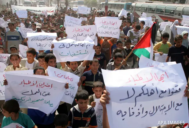 Palestinian children hold signs during a protest against the health sector strike outside Nase Hospital in the southern Gaza strip town of Khan Younis, Thursday, Aug. 30, 2007. Dozens of women and children staged a sit i...