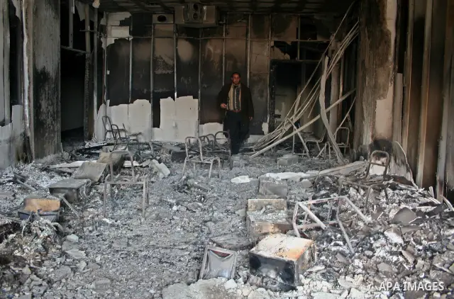 Palestinians inspect a burnt building inside the Islamic University after it was attacked in Gaza. Fighting between rival Palestinian factions escalated across Gaza on Friday, killing at least 17 people, as Hamas Islamis...