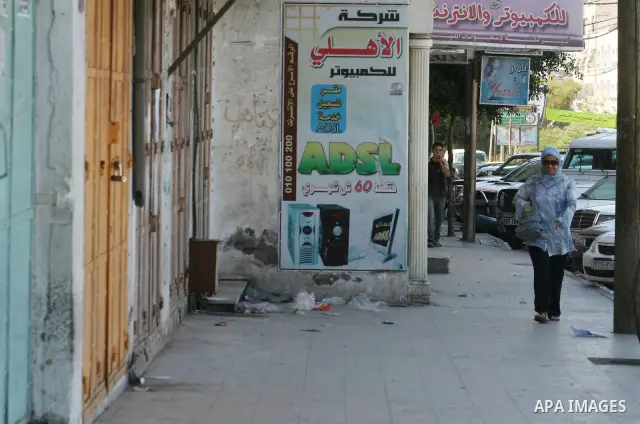 Palestinians walk passed closed shops during a general strike called by supporters of the Fatah Movement in the West Bank. Activists in the Fatah movement declared a general strike across the Gaza Strip and parts of the...