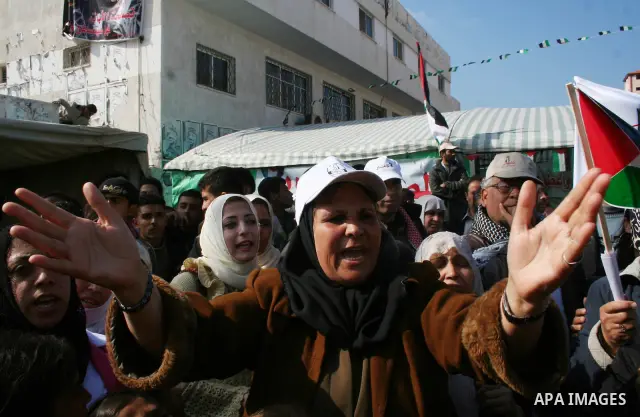 Palestinians shout slogans and hold Palestinian flags during a demonstration against the internal fighting between the Hamas and Fatah movements in Gaza City.