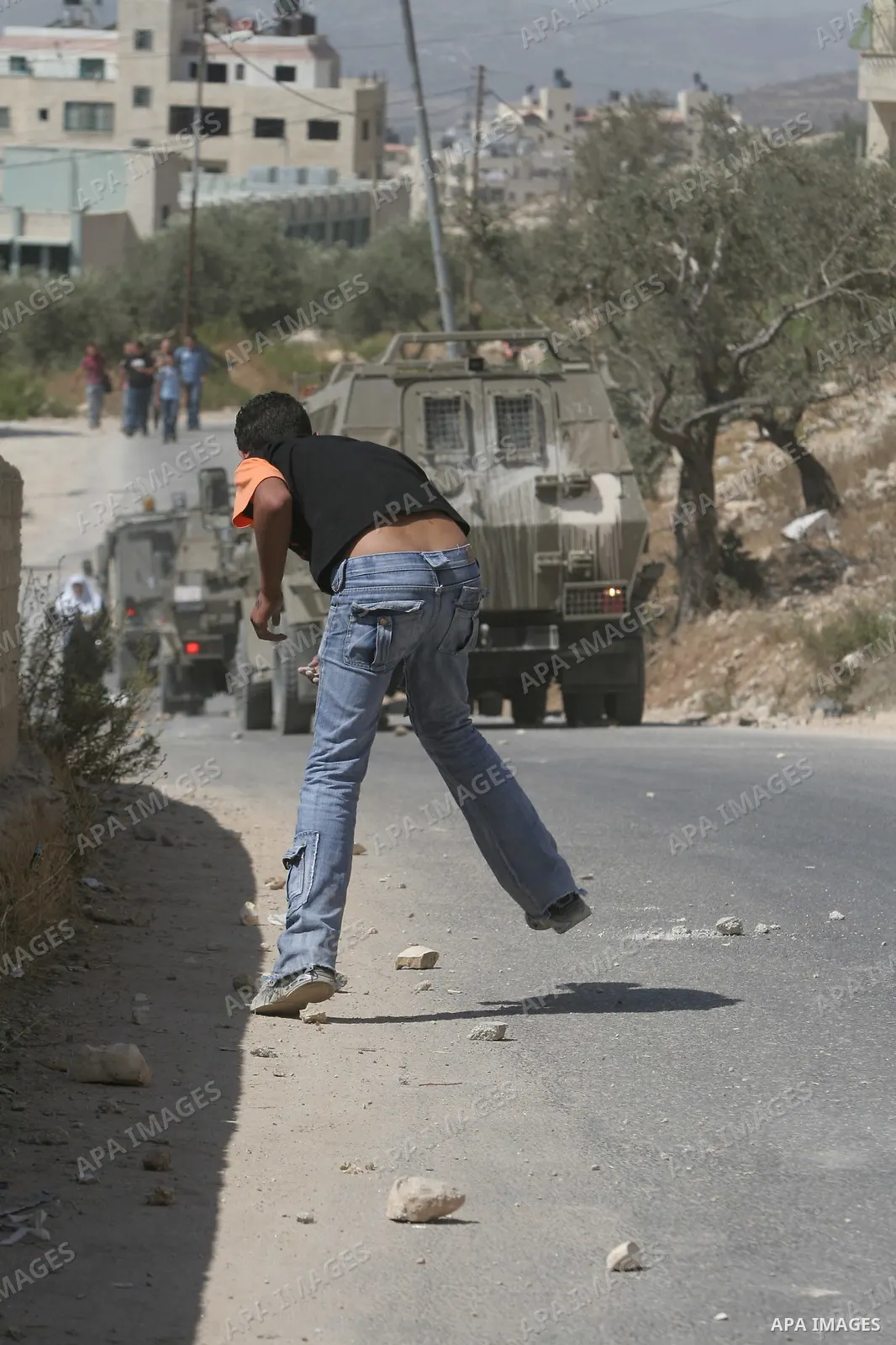 Palestinian youth hurling stones at Israeli troops raiding the West Bank town of Nablus. A Palestinian boy was wounded during the clashes, hospital sources said.