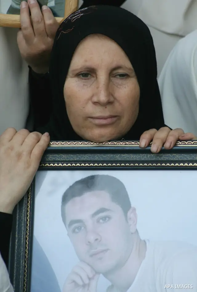 A Palestinian woman holds picture of her incarcerated relative as she attend a protest calling for the release of Palestinian prisoners held in Israeli jails, in Gaza. Israel began freeing dozens of Palestinian prisoners...