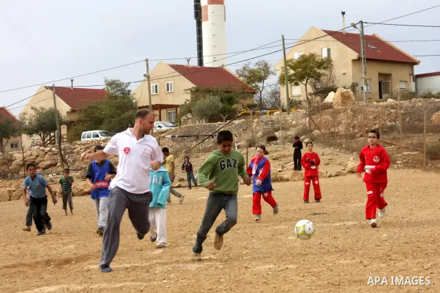 Israeli children from Kibbutz Harel (blue jerseys) play football with Palestinian children in the Umm al-Kheir village, near the West Bank city of Hebron, on December 30, 2011. Photo by Mamoun Wazwaz