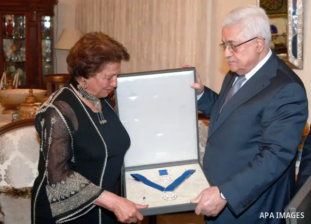 Palestinian President Mahmoud Abbas, gives the artist Tamam shamoot , the order of Merit and Excellence in the Jordan Capital of Amman, on Mar. 26, 2012. Photo by Thaer Ganaim