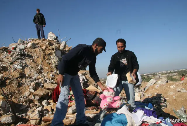 Palestinians inspect the rubble from the destroyed house of a relative following an overnight Israeli army operation in Deir al-Balah, near the border between the Gaza Strip and Israel. Dozens of rockets were fired at Is...