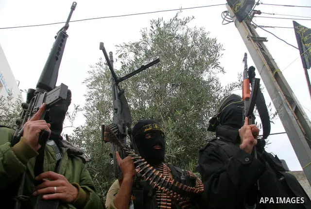 Masked Palestinian militants hold their weapons during an Islamic Jihad rally in Bureij, central Gaza Strip, Friday, Dec. 26, 2008. Israeli defense officials say politicians have approved a large-scale incursion into the...