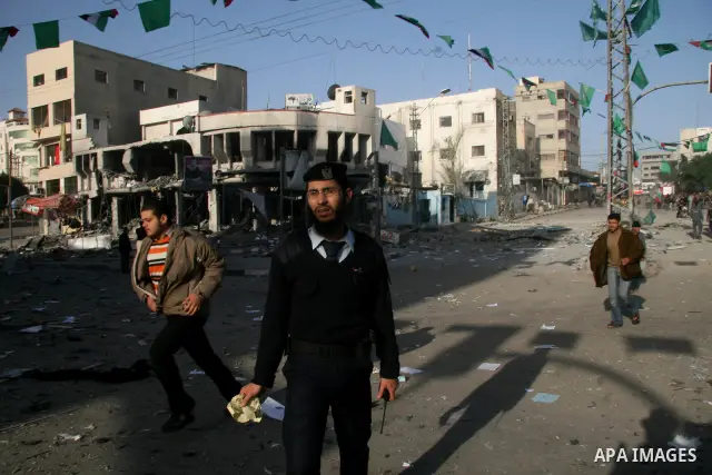 Palestinians look at destroyed buildings after an explosion from an Israeli missile strike in Gaza City. Israeli warplanes pounded the Hamas-ruled Gaza Strip for a third consecutive day on Monday and the Jewish state pre...