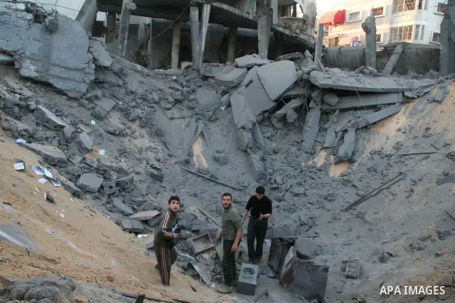 Palestinians look at destroyed buildings after an explosion from an Israeli missile strike in Gaza City. Israeli warplanes pounded the Hamas-ruled Gaza Strip for a third consecutive day on Monday and the Jewish state pre...