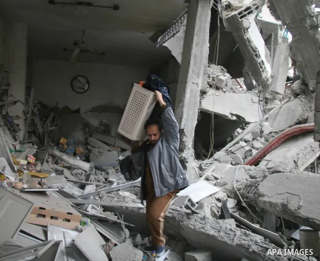 Palestinians look at destroyed buildings after an explosion from an Israeli missile strike in Gaza City. Israeli warplanes pounded the Hamas-ruled Gaza Strip for a third consecutive day on Monday and the Jewish state pre...