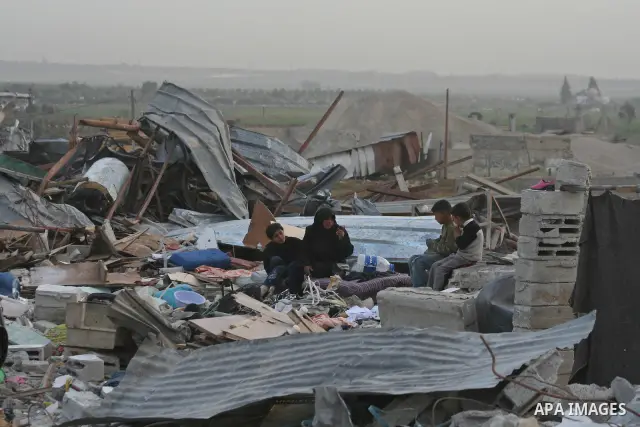 Palestinians walk on the rubble of destroyed buildings in the east of Jebaliya, northern Gaza Strip, Wednesday, Jan. 29, 2009. The last Israeli troops left the Gaza Strip before dawn Wednesday, the military said, as Isra...