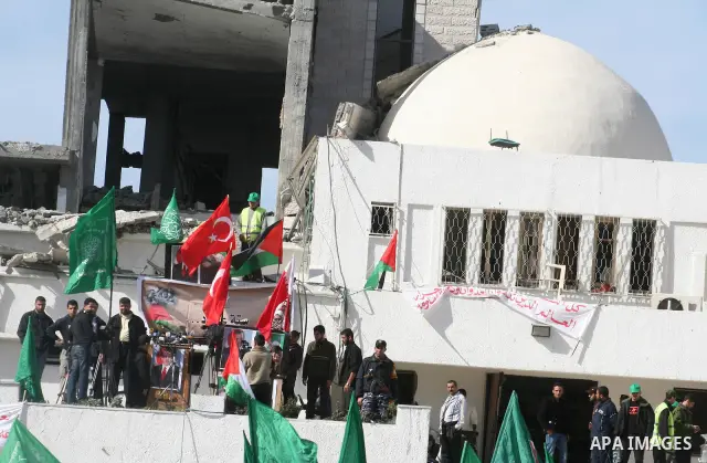 A Turkish flag is seen as Palestinians pray in front of the destroyed parliament building prior to attending a rally in support of Hamas in Gaza city, Friday Jan. 30, 2009. Turkish Prime Minister Tayyip Erdogan is winnin...