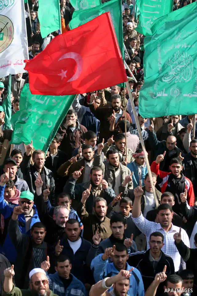 A Turkish flag is seen as Palestinians pray in front of the destroyed parliament building prior to attending a rally in support of Hamas in Gaza city, Friday Jan. 30, 2009. Turkish Prime Minister Tayyip Erdogan is winnin...