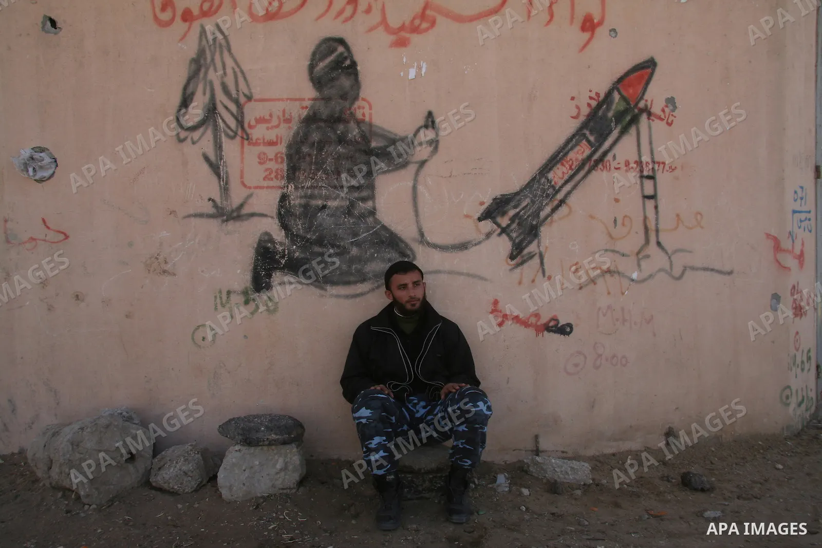Members of Hamas security forces sit in front of anti-Israel graffiti in the northern Gaza Strip February 15, 2009. Prospects for a stable truce in Gaza ran into trouble on Saturday when Israel insisted on the release of...