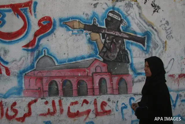 A Palestinian woman walk next a Hamas grafiti that reads in arabic 'be careful' in the streets of Gaza City February 15, 2009 APAIMAGES PHOTO / Ashraf Amra