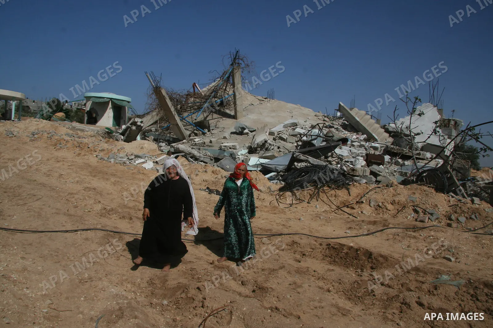A Palestinian woman walks past a house destroyed during Israel's 22-day offensive in Jabalia in the northern Gaza Strip on February 15, 2009 APAIMAGES PHOTO / Ashraf Amra