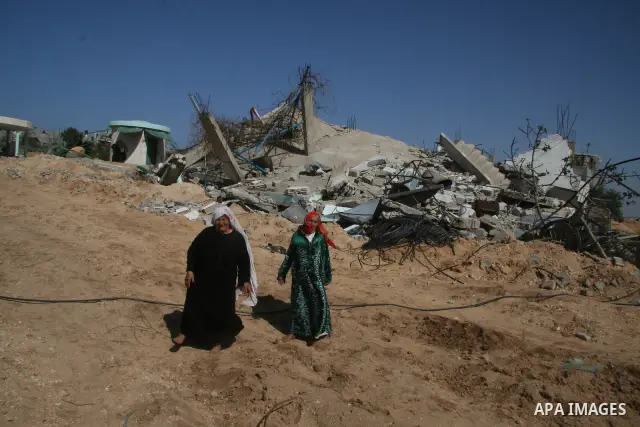 A Palestinian woman walks past a house destroyed during Israel's 22-day offensive in Jabalia in the northern Gaza Strip on February 15, 2009 APAIMAGES PHOTO / Ashraf Amra