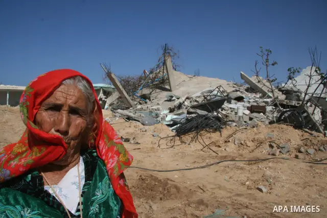 A Palestinian woman walks past a house destroyed during Israel's 22-day offensive in Jabalia in the northern Gaza Strip on February 15, 2009 APAIMAGES PHOTO / Ashraf Amra
