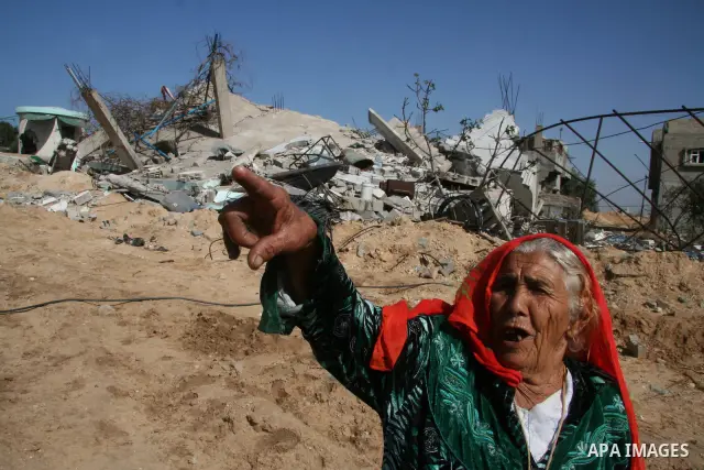 A Palestinian woman walks past a house destroyed during Israel's 22-day offensive in Jabalia in the northern Gaza Strip on February 15, 2009 APAIMAGES PHOTO / Ashraf Amra