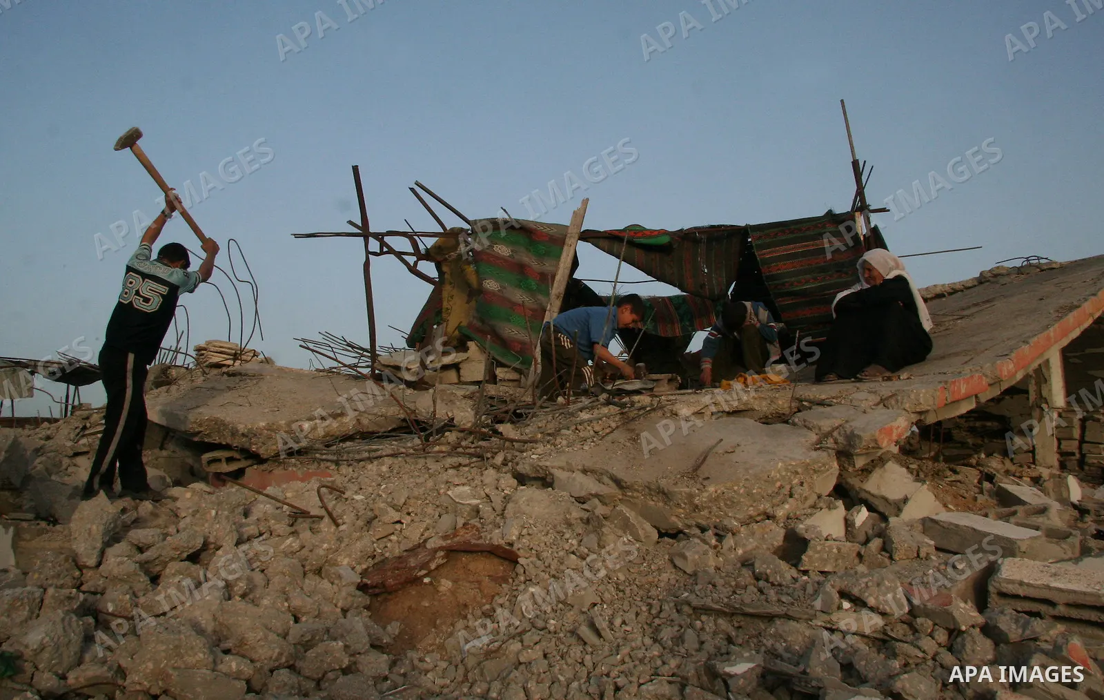 A Palestinian family works on the rubble of their home destroyed during Israel's 22-day offensive in Jabalia in the northern Gaza Strip on February 16, 2009. Israeli aircraft struck smuggling tunnels on Gaza's border wit...