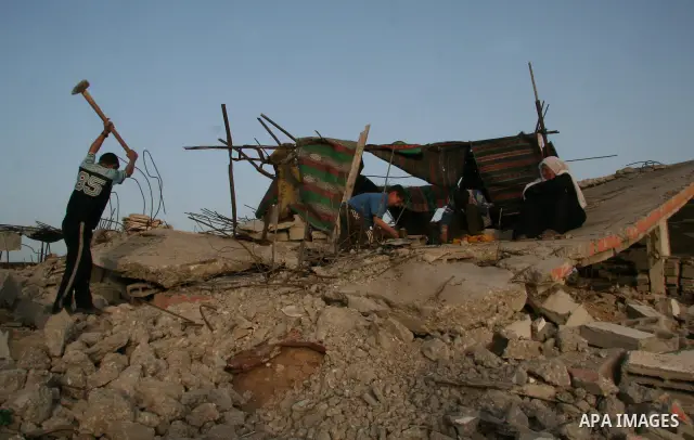 A Palestinian family works on the rubble of their home destroyed during Israel's 22-day offensive in Jabalia in the northern Gaza Strip on February 16, 2009. Israeli aircraft struck smuggling tunnels on Gaza's border wit...