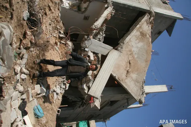 A Palestinian family sit on the rubble of their home destroyed during Israel's 22-day offensive in Jabalia in the northern Gaza Strip on February 18, 2009 APAIMAGES PHOTO / Ashraf Amra