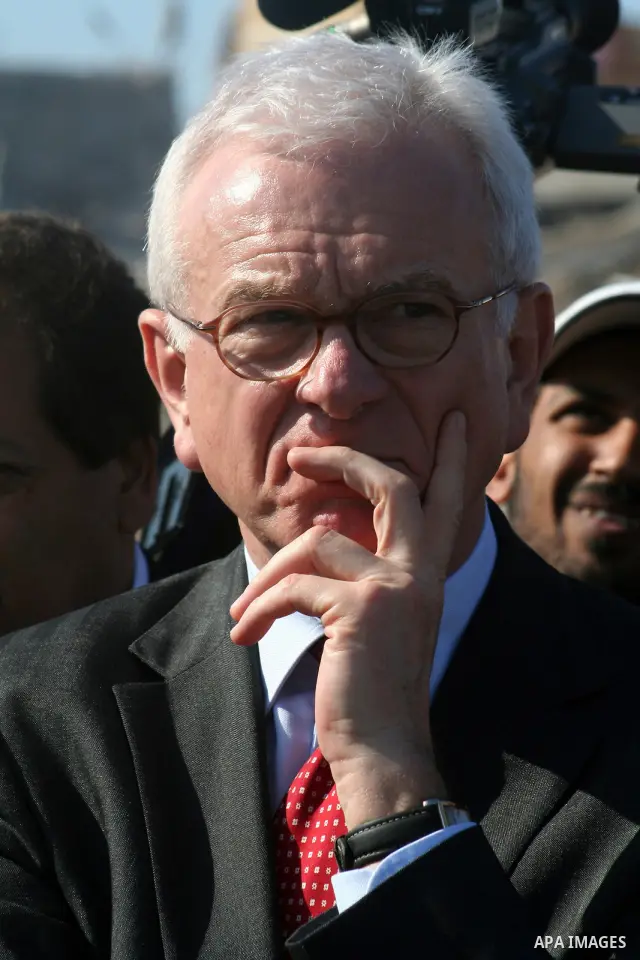 European Union (EU) Parliament President Hans-Gert Poettering (R) hold hands with a Palestinian man during a visit to a Jabalia district that was bombed during Israel's 22-day offensive on the Gaza Strip, on February 23,...