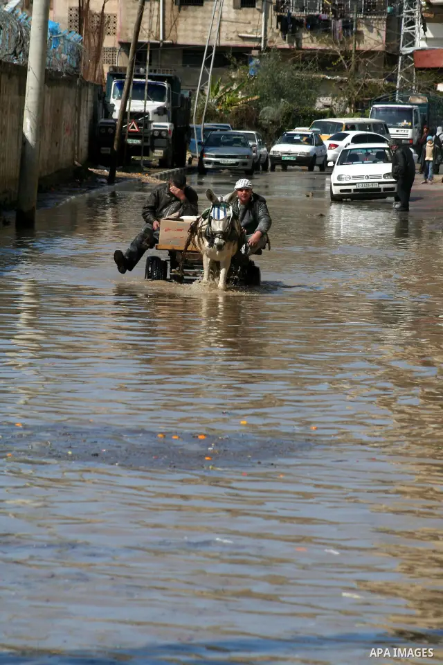 Palestinians ride on a horse cart after heavy rain in Gaza March 1, 2009. The World Bank said on Sunday it would urge international financial support for rebuilding the Gaza Strip through direct donation to both the West...