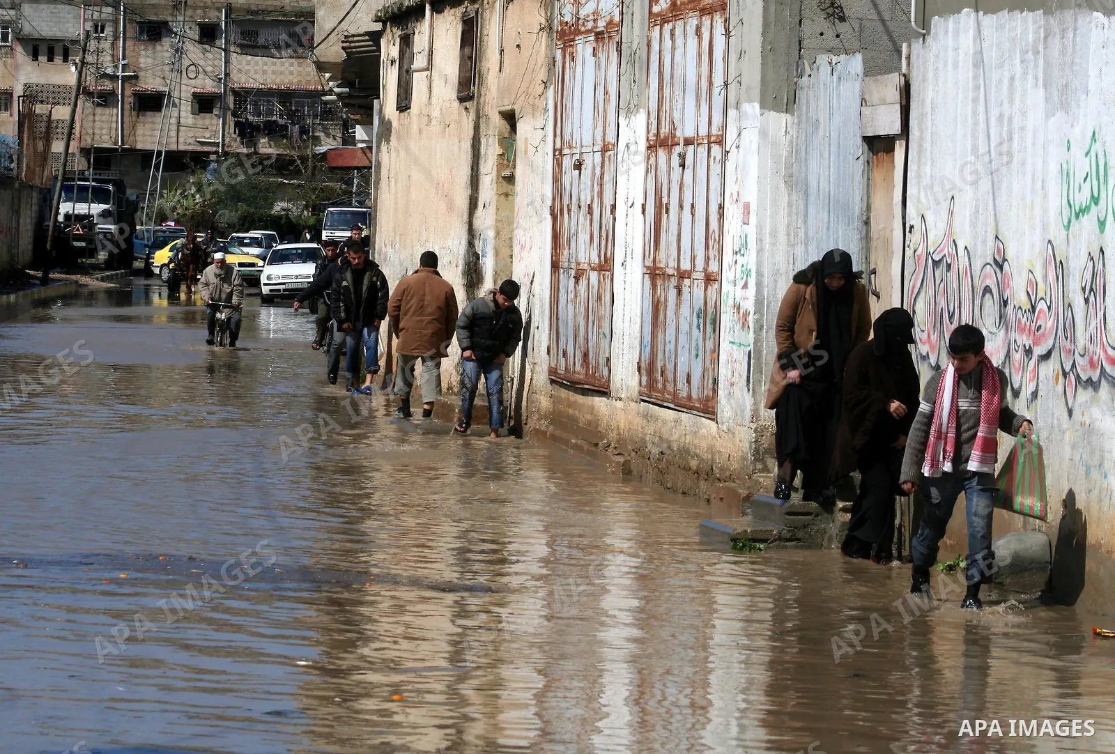 A Palestinian man tries to remove water from his front steps as the street floods during a heavy rainstorm in northern gaza strip, Sunday, March 1, 2009. APAIMAGES PHOTO / Ashraf Amra