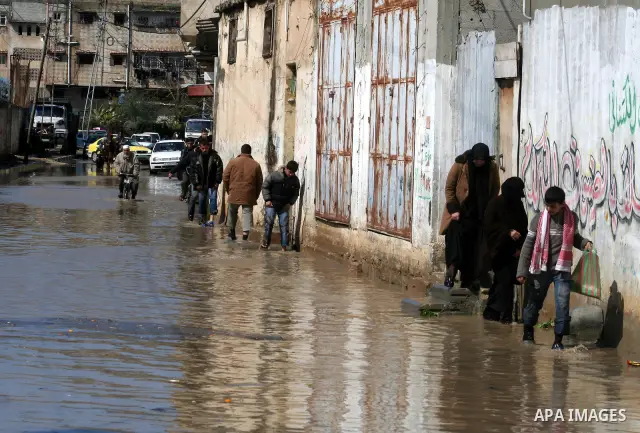 A Palestinian man tries to remove water from his front steps as the street floods during a heavy rainstorm in northern gaza strip, Sunday, March 1, 2009. APAIMAGES PHOTO / Ashraf Amra