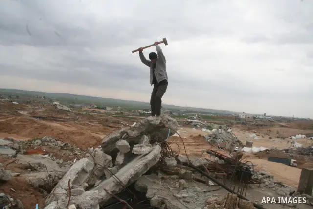 Palestinian men break concrete in the rubble of a house which was destroyed during Israel's 22-day offensive in Jabalia in the northern Gaza Strip on March 2, 2009. US Secretary of State Hillary Clinton said that aid to...