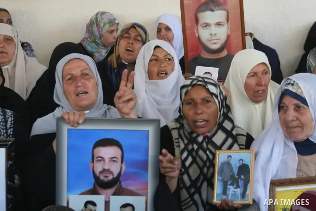 A Palestinian woman holds a picture of a relative held in an Israeli jail during a weekly protest calling for their release, outside the International Red Cross headquarters in Gaza City.