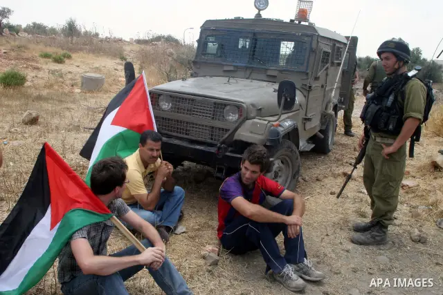 Israeli soldiers detain Palestinian and international protestors during a demonstration against the construction of the controversial Israeli cement barrier in the West Bank village of Nilin near Ramallah. Palestinian, I...
