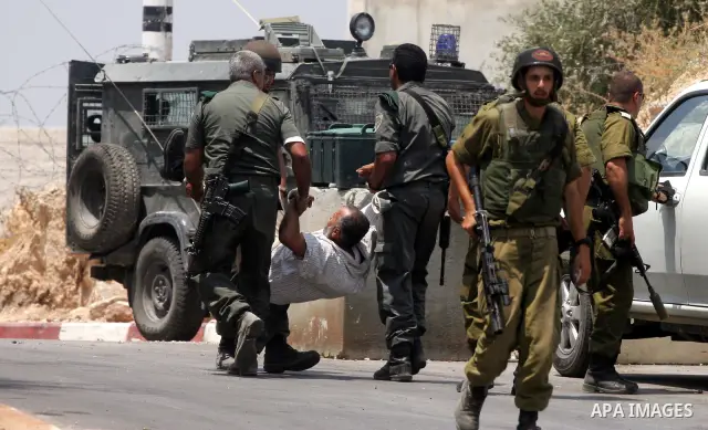 Israeli soldiers detain Palestinian and international protestors during a demonstration against the construction of the controversial Israeli cement barrier in the West Bank village of Nilin near Ramallah. Palestinian, I...