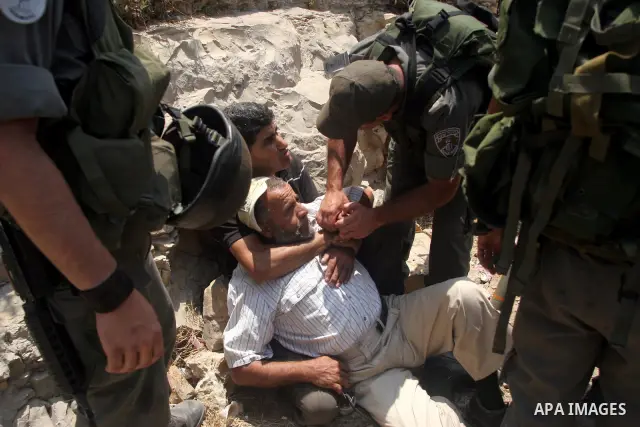 Israeli soldiers detain Palestinian and international protestors during a demonstration against the construction of the controversial Israeli cement barrier in the West Bank village of Nilin near Ramallah. Palestinian, I...