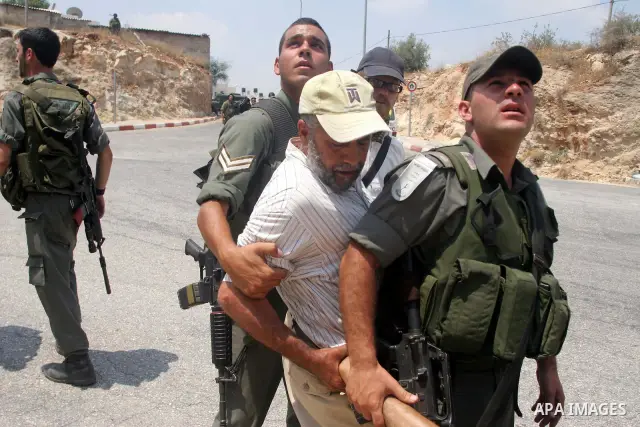 Israeli soldiers detain Palestinian and international protestors during a demonstration against the construction of the controversial Israeli cement barrier in the West Bank village of Nilin near Ramallah. Palestinian, I...